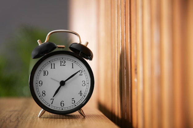 Alarm clock on wooden table at home Morning time