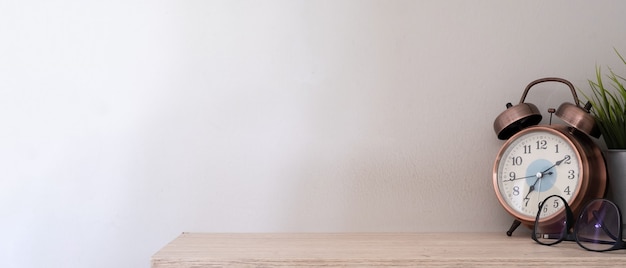 Alarm clock on a wooden table on white background banner