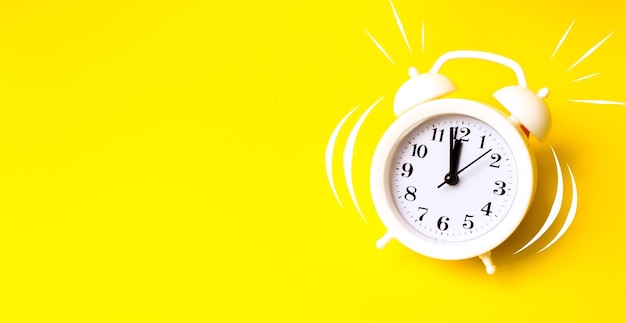 Alarm clock on yellow background top view Flat lay copy space. Minimalistic background,