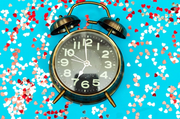 alarm vertoont 7 oclock met kleurrijke hart confetti feestdagen tijd concept