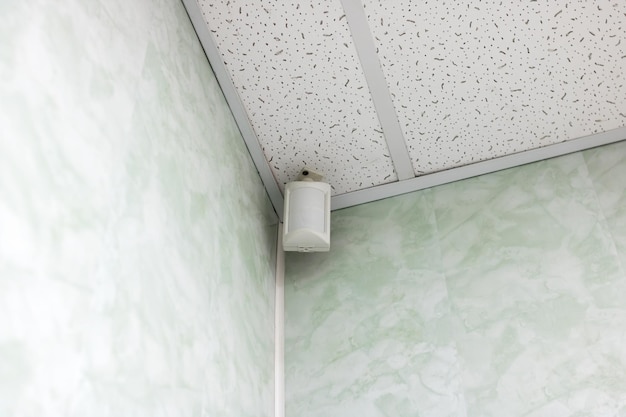 Alarmsensor in hoek aan plafond van kamer