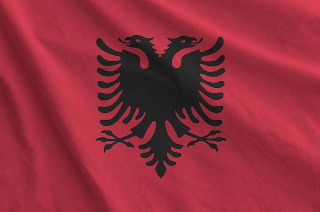 Albanese vlag afgebeeld op gevouwen golvende stof van oude doek