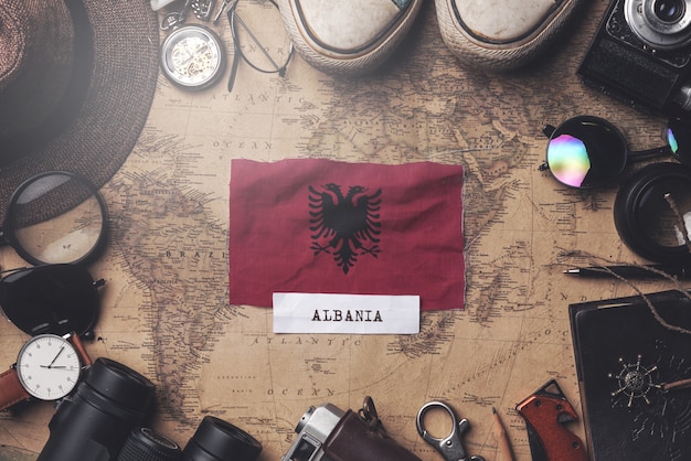 Albania Flag Between Traveler's Accessories on Old Vintage Map. Overhead Shot