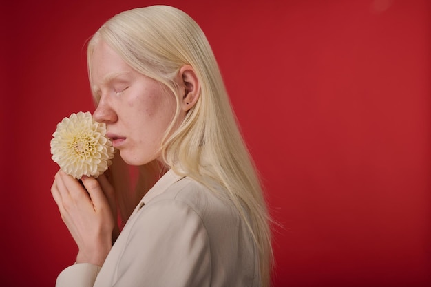 Ragazza albina in posa con il fiore