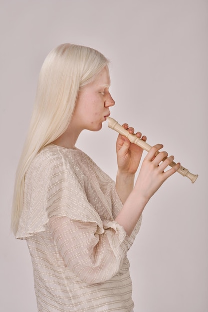 Foto albino meisje speelt op fluit