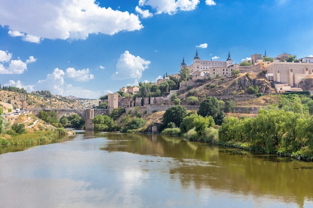 Photo alcazar and alcantara bridge of toledo skyline