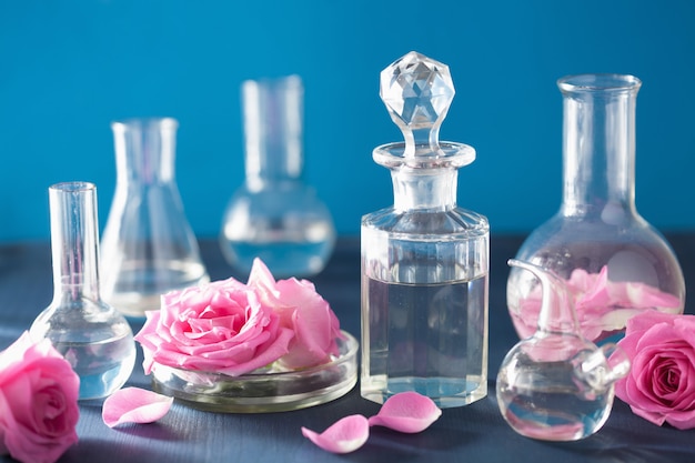 Alchemie en aromatherapie met rozenbloemen en chemische kolven