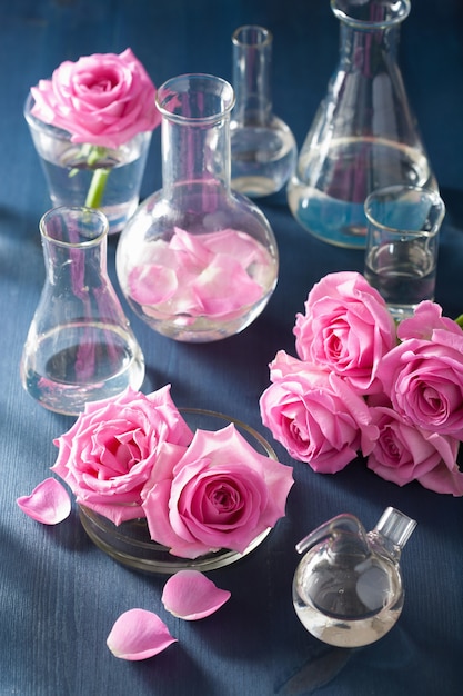 Foto alchemie en aromatherapie set met roze bloemen en chemische kolven