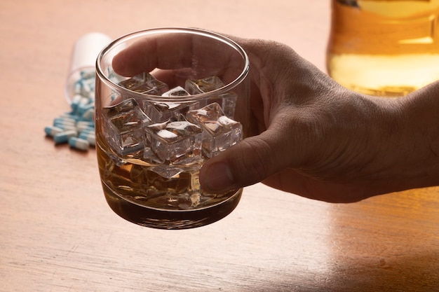 氷と錠剤とウイスキーのガラスとアルコール乱用