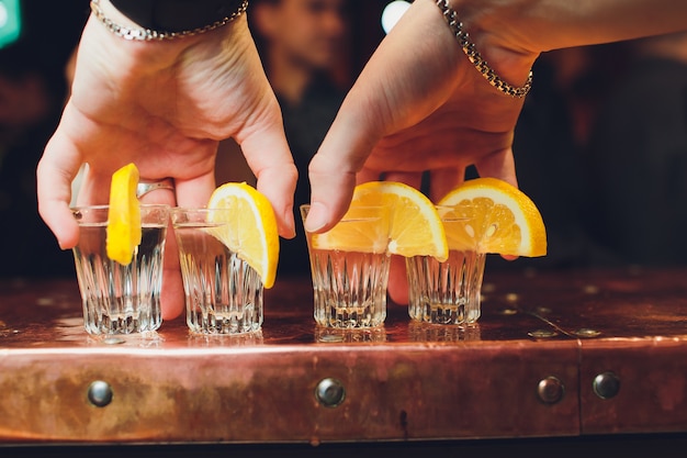 Alcohol cocktail with brandy, whiskey, lemon and ice in small glasses, selective focus.