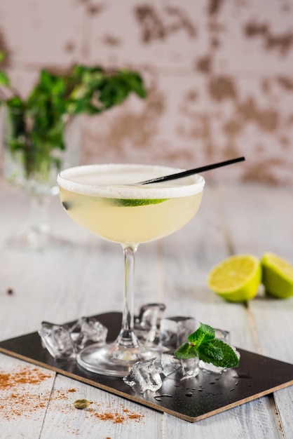 An alcohol cocktail with lime in glass on white background