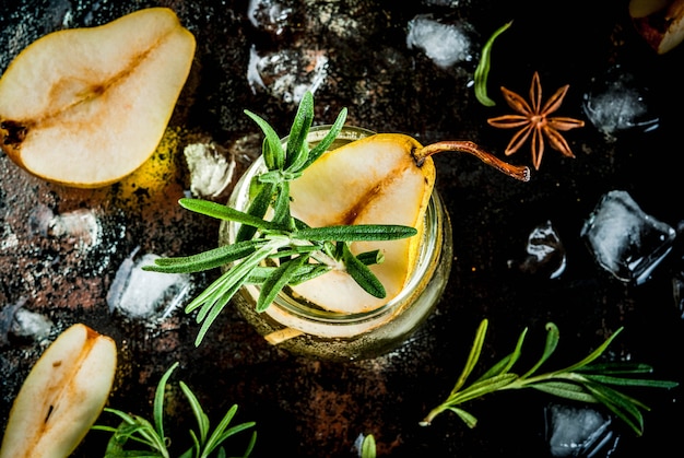 Alcohol drink, Sweet pear cocktail with rum, liquor, anise and rosemary, On a black rusty metallic ,  top view
