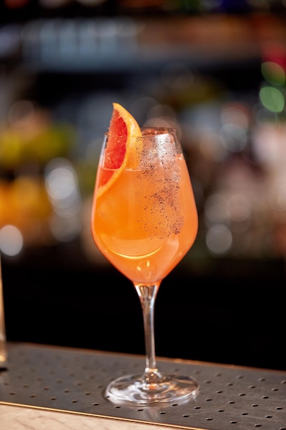 alcohol drinks and luxury concept - glass of grapefruit cocktail at bar