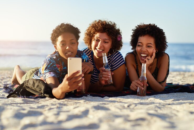 Foto alcohol ontspannen en selfie met vrienden op het strand samen voor zomervakantie reis of vakantie bonding liefde en glimlach met een groep gelukkige mensen op het zand bij de zee voor sociale media profiel foto