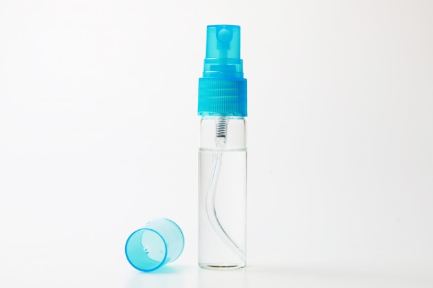 Foto bottiglia dello spruzzo di alcool su fondo bianco