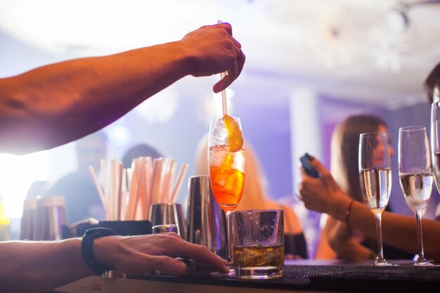 Alcoholic beverage based on table with ice cubes and oranges