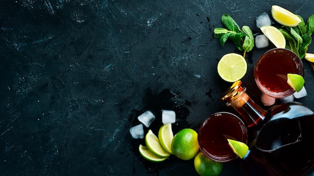 Alcoholic Beverage Rum lime and mint on a black stone background Top view Free space for your text