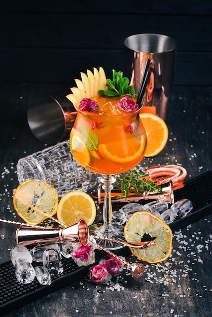 Photo alcoholic cocktail aperol spritz with roses on a black wooden background