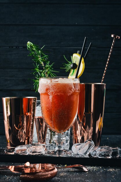 Alcoholic Cocktail Bloody Mary Tomato juice and rosemary On a black wooden background