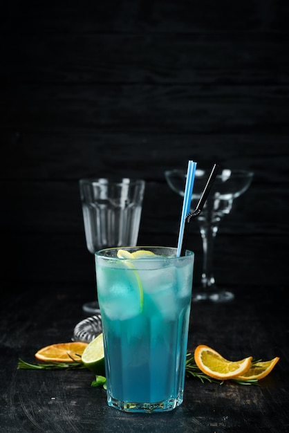 Cocktail alcolico blue lagoon bere su uno sfondo di legno vista dall'alto