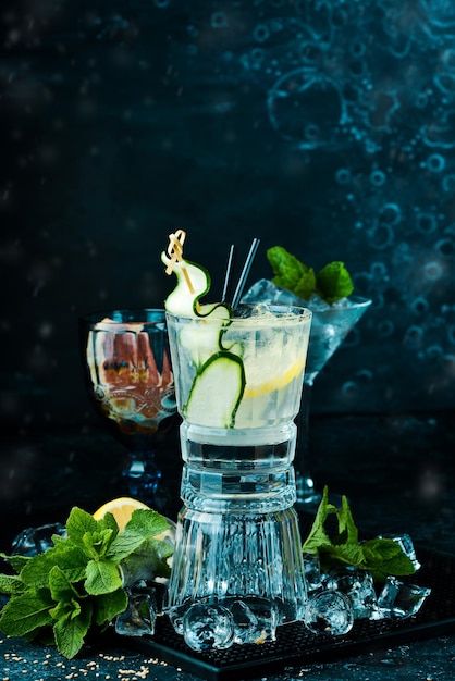 Alcoholic cocktail Gin and tonic with cucumber on a black stone background Menu bar Alcohol
