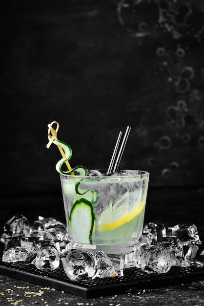 Alcoholic cocktail Gin and tonic with cucumber on a black stone background Menu bar Alcohol