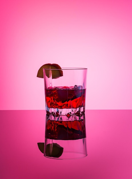 Alcoholic cocktail Glass with drinks vodka apple liqueur ice apple slice on pink background