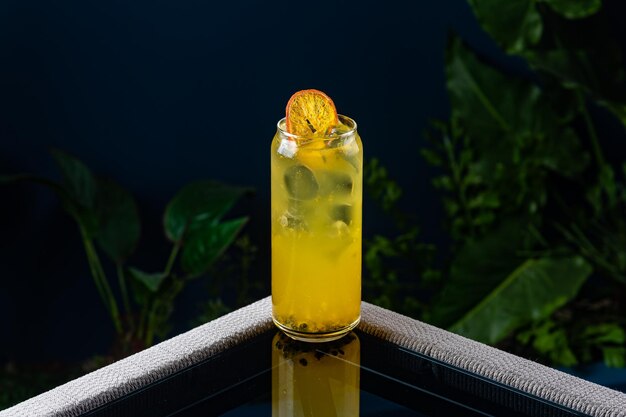青い背景と植物に対して透明なテーブルの上のアルコール カクテル