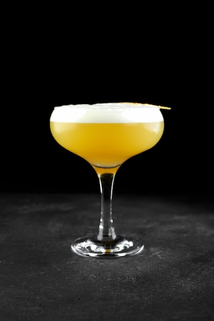 Alcoholic cocktail whiskey sour on black background