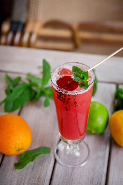 Foto cocktail alcolico con caramelle e foglie di menta di sake lampone liquore al frutto della passione e succo di ananas