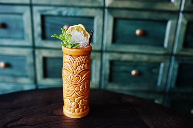 Alcoholic cocktail with mint in originally earthen glass on bar table