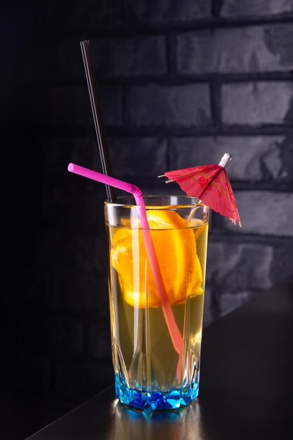 Alcoholic cocktail with orange slices in a blue glass