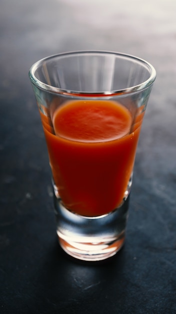 Alcoholic drink with tomato juice on shot glass