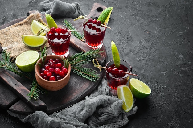Alcoholic liqueur from a cranberry in a glass Cranberry lime rosemary On a rustic background Top view Free space for your text