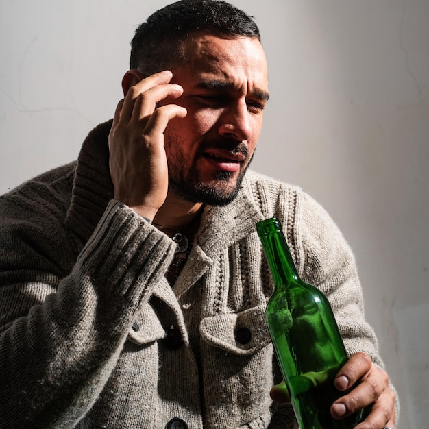 Foto uomo alcolizzato con bottiglie vino piangere uomo depresso piangere uomini ubriachi che bevono alcol sentirsi soli a