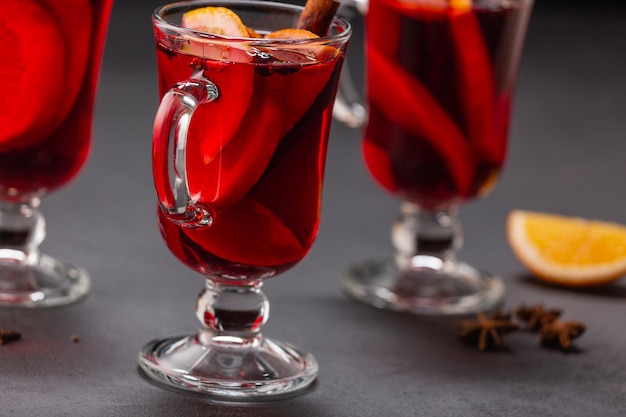 Alcoholic mulled wine with fruits and spices on a dark background, traditional alcoholic drink, Christmas