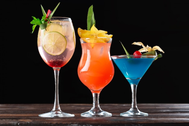 Alcoholic and non alcoholic cocktails on wooden table. Summer cold drinks