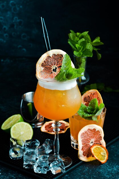 Alcoholic orange cocktail with liqueur in a glass On a black stone background Menu bar