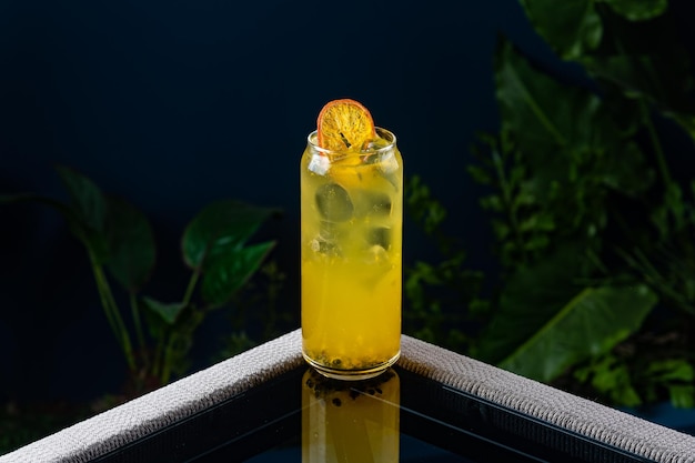 Alcoholische cocktail op een transparante tafel tegen een blauwe achtergrond en planten