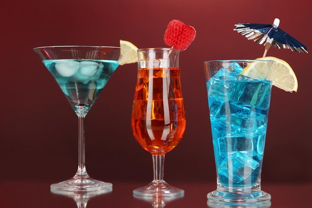 Alcoholische cocktails met ijs op donkere rode achtergrond