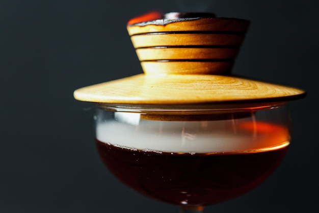 Alcoholische drank Een cocktail met whisky of cognac met vuur en rook close-up donkere zwarte achtergrond