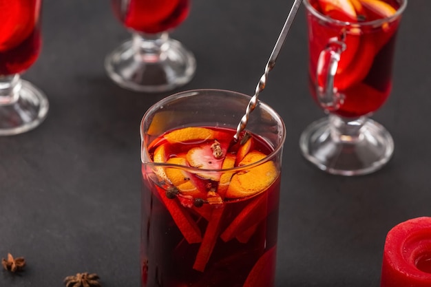 Alcoholische glühwein met fruit en kruiden op een donkere achtergrond, traditionele alcoholische drank, Kerstmis