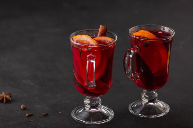 Alcoholische glühwein met fruit en kruiden op een donkere achtergrond, traditionele alcoholische drank, Kerstmis