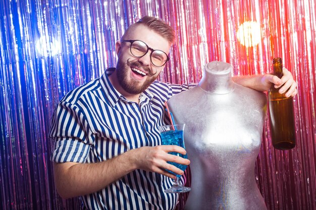 Alcoholism, fun and fool concept - Drunk guy at party in a nightclub.