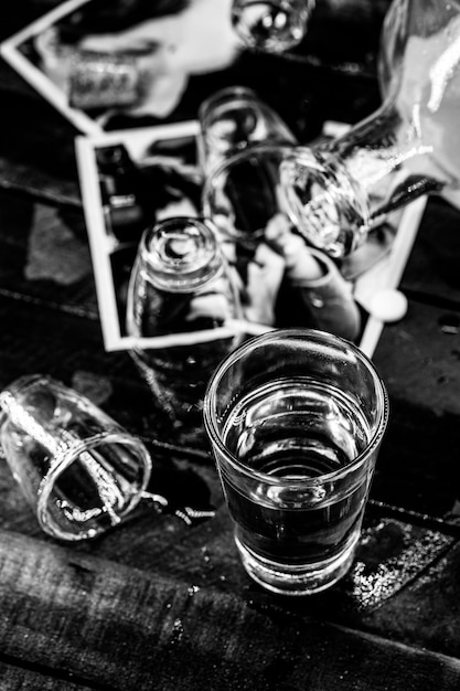 Alcoholverslaving Glazen en drank gemorst over foto's van een gezin Selectieve focus Ernstige echtscheiding of alcoholisme concept