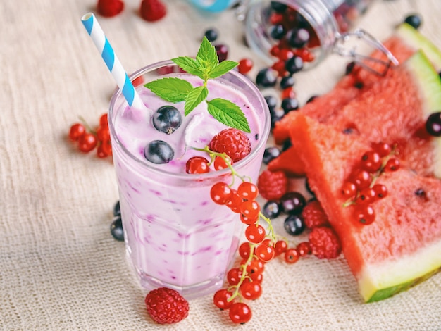 alcoholvrije milkshake smoothies met verse bessen, frambozen, plakjes watermeloen en muntblaadjes op linnen textiel, fitnesscocktails en eten, biologische natuurproducten