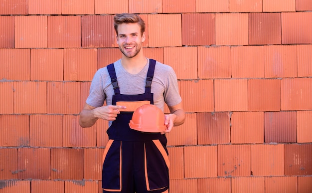 Algemeen onderhoud reparatie werknemer fix onderhouden gebouw. Inspecteer diagnose problemen erachter te komen manier correct. Man bouwt huis. Gebouw inspecteren. Werknemer bakstenen muur achtergrond. Bouw constructie.