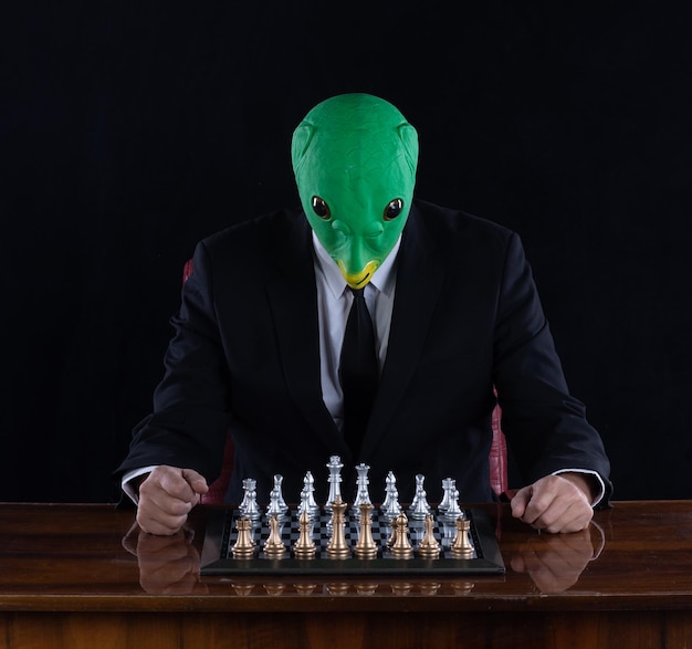 alien playing chess, black studio background