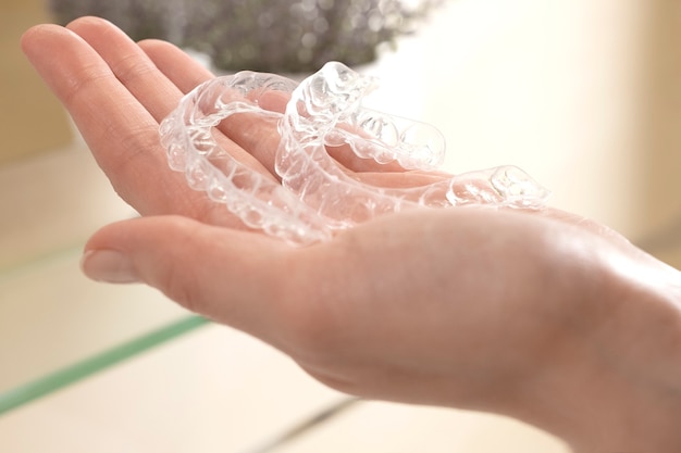 Foto aligners voor het corrigeren van de beet van tanden op de vrouwelijke handpalm.