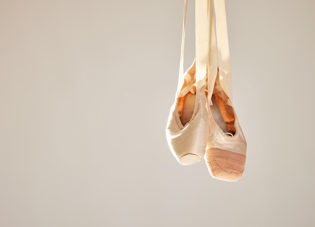 All ballet is dance but not all dance is ballet Shot of a pair on ballet shoes hanging in a dance studio